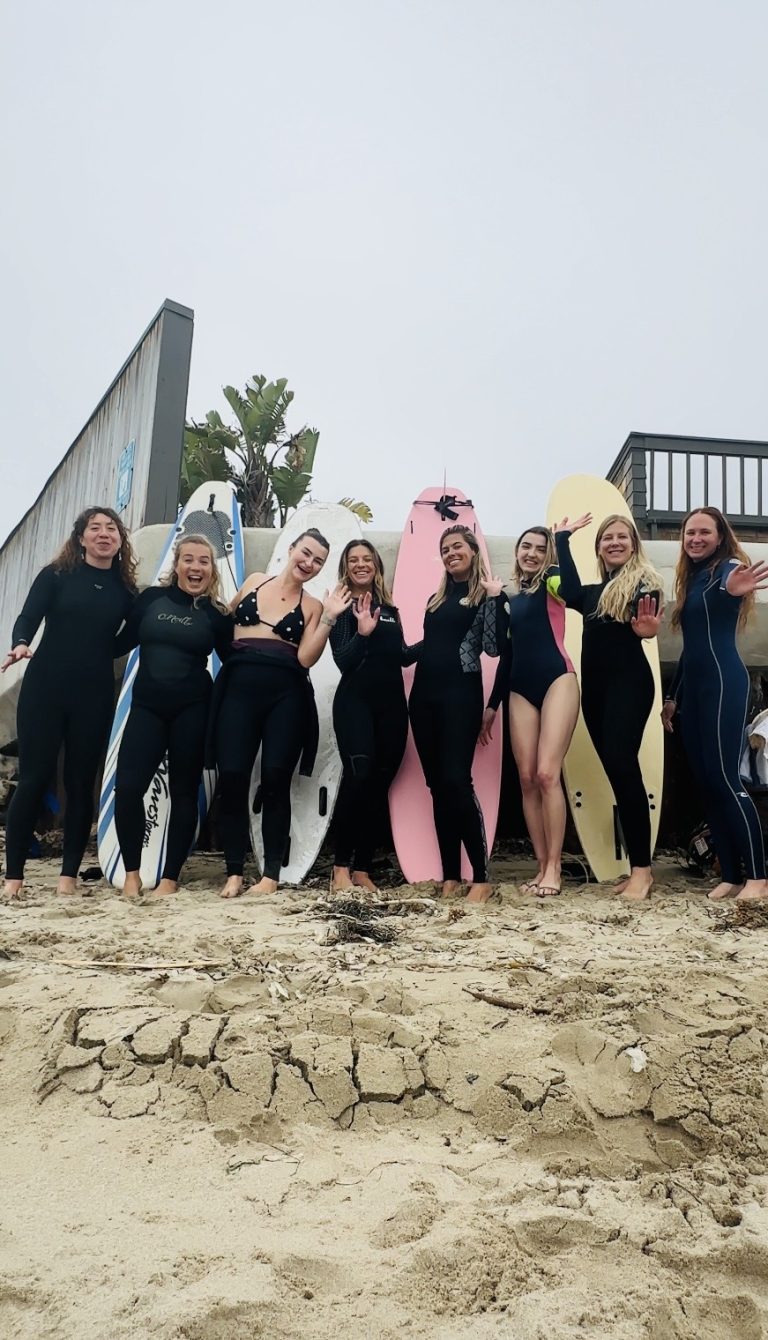 Women in wetsuits holding surfboards after a Ventura Surf Girlies lesson in Ventura, CA